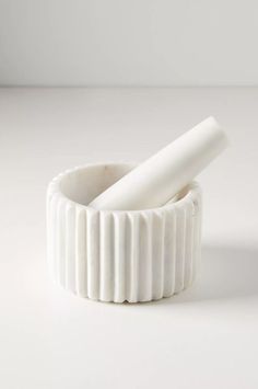 an empty white container with two rolled up rolls in the middle on a white surface