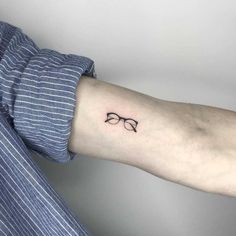 a person's arm with glasses tattoo on it