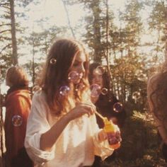 a group of people blowing bubbles in the woods