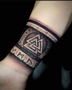 a man's arm with a tattoo on it and an image of a triangle