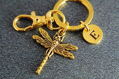 a gold dragonfly keychain on a black surface