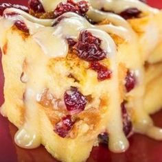 cranberry bread pudding with icing on a red plate