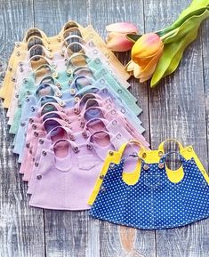 several pairs of baby shoes sitting next to each other on a wooden surface with tulips