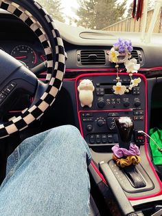 the interior of a car is decorated with flowers and stuffed animals as well as steering wheel controls