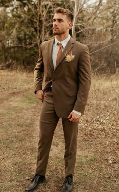 a man in a suit and tie standing in the grass