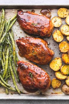 two meats and potatoes on a tray with gravy next to green beans