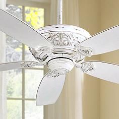 a white ceiling fan in front of a window with curtains and windowsills behind it