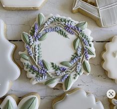 cookies decorated with flowers and leaves are arranged on a white table next to cookie cutters