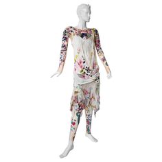 Rare Christian Dior S/S 2004 20's inspired silk chiffon flapper dress by John Galliano. Includes tattoo body suit with matching footless leggings. Identical to the runway photo. Delicate feminine 20's style flapper dress is bias cut and fashioned in floral patchwork pattern silk on white ground. Intricately manipulated fabric representative of Galliano's iconic signature construction. Features a creme chemise style bodice overlaid both front and back in floral silk. Slip attached. Matching tatto 2004 Tattoo, Leggings Bodysuit, Tattoo Leggings, Galliano Dior, Jacques Fath, Delicate Feminine, Dior Haute Couture, 20s Fashion, Floral Patchwork