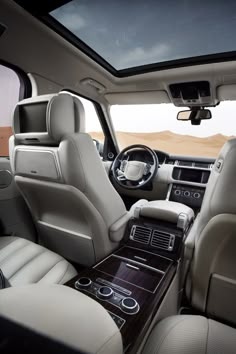 the interior of a luxury vehicle with leather seats and dashboard, steering wheel and center console