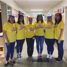 a group of women in yellow shirts standing next to each other on a hallway way