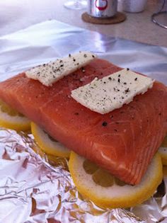 a piece of salmon sitting on top of lemon slices