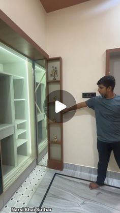 a man standing in front of a glass display case with his hand on the door