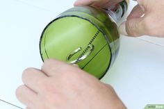 a person using a green mouse on top of a white table next to a hand