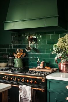 a stove top oven sitting inside of a kitchen next to a green tiled countertop