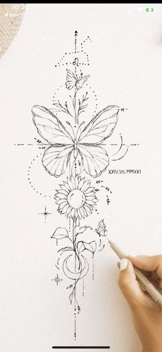 someone is drawing a flower on paper with a pen and inking it in the shape of a butterfly