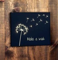 a black canvas with a dandelion saying make a wish