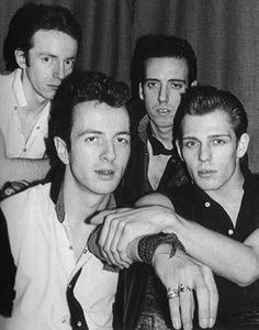 black and white photograph of five young men posing for the camera with their arms around each other