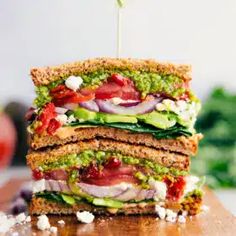 a cut in half sandwich sitting on top of a wooden cutting board