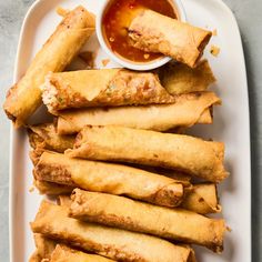 some fried food on a white plate with dipping sauce