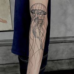 a man with a tattoo on his arm has a jellyfish in it's head