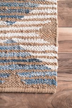 a close up of a rug on the floor with wood floors in the background,