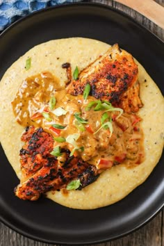 grilled chicken breast with mustard sauce and tortilla on a black platter