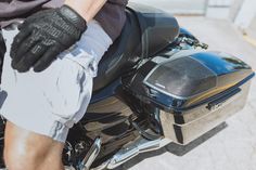 a close up of a person on a motorcycle wearing gloves and holding the handlebars