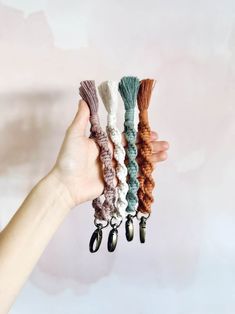 a hand holding five different colored hair clips