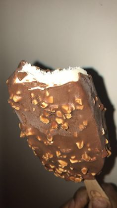 a person holding an ice cream with nuts on it