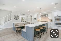 a large kitchen with an island in the middle and stools at the counter top