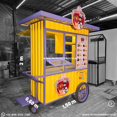 a yellow and purple food cart sitting inside of a building next to a white wall