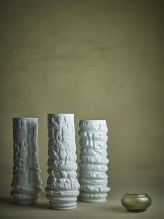 three white vases sitting next to each other