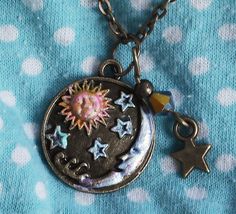 "A cute necklace to pop on when you want to add a little celestial style to your outfit! A little sun and moon pendant is accented with touches of violet and golden-pink and tiny stars are detailed in light turquoise blue! A Swarovski crystal bicone bead dangles at one side along with a little star charm, adding sparks of purple light! Just choose your favorite length and make it yours! Antiqued Gold-plated Charm 3/4\" round, Antiqued Gold-plated Necklace w/ Lobster Clasp 18\"-28\" MORE ARTFUL I Cool Necklaces Unique, Whimsigoth Aesthetic Fashion, Sun And Moon Pendant, Celestial Style, Whimsical Accessories, Bead Dangles, Star Pendant Necklace, Hippie Necklace, Purple Light