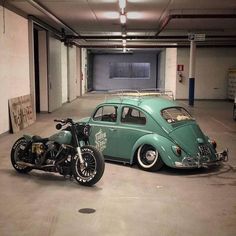 an old vw bug is parked in a parking garage with a motorcycle and side car