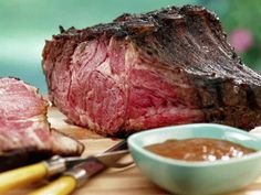 a white bowl filled with beef strips on top of a colorful cloth covered tablecloth