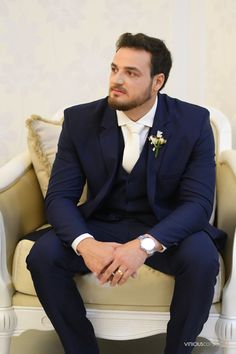 a man in a suit sitting on a chair