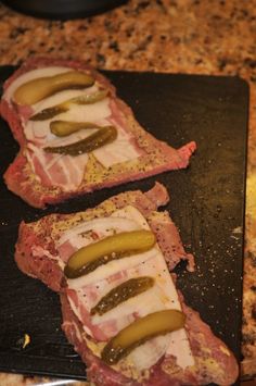 two slices of meat with pickles on them