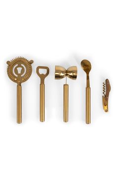 five golden kitchen utensils lined up in a row