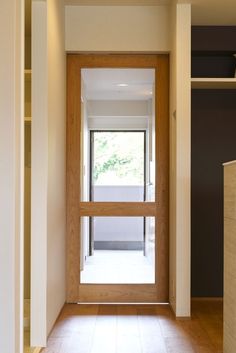 an empty room with a wooden door and window on the wall, in front of a tiled floor