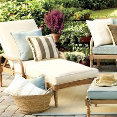 an outdoor patio furniture set with cushions and pillows on the ground next to potted plants