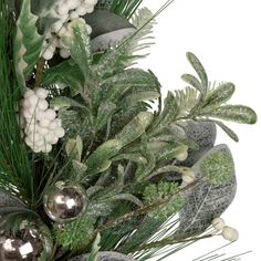 an arrangement of greenery and silver ornaments