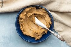 a blue bowl filled with peanut butter on top of a table