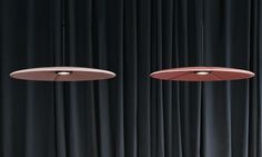 three circular lights hanging from the ceiling in front of black curtains