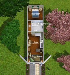 an aerial view of a small house in the middle of a field with trees and bushes