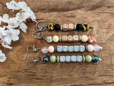 the name nurse spelled out with beads and keychains on a wooden table next to flowers