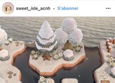 an image of a fake snow scene with trees and flowers on the rocks in the water