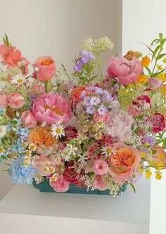 a vase filled with lots of different colored flowers