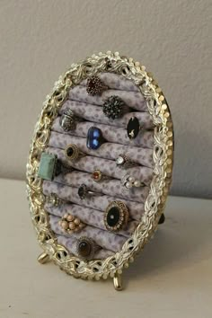 there is a ring holder made out of fabric and gold chains with rings on it