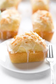 a white plate topped with cupcakes covered in frosting and icing next to a fork